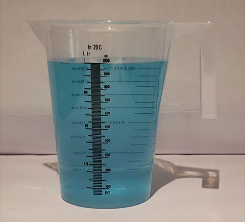Measuring cups and food coloring set up for the freshwater demonstration